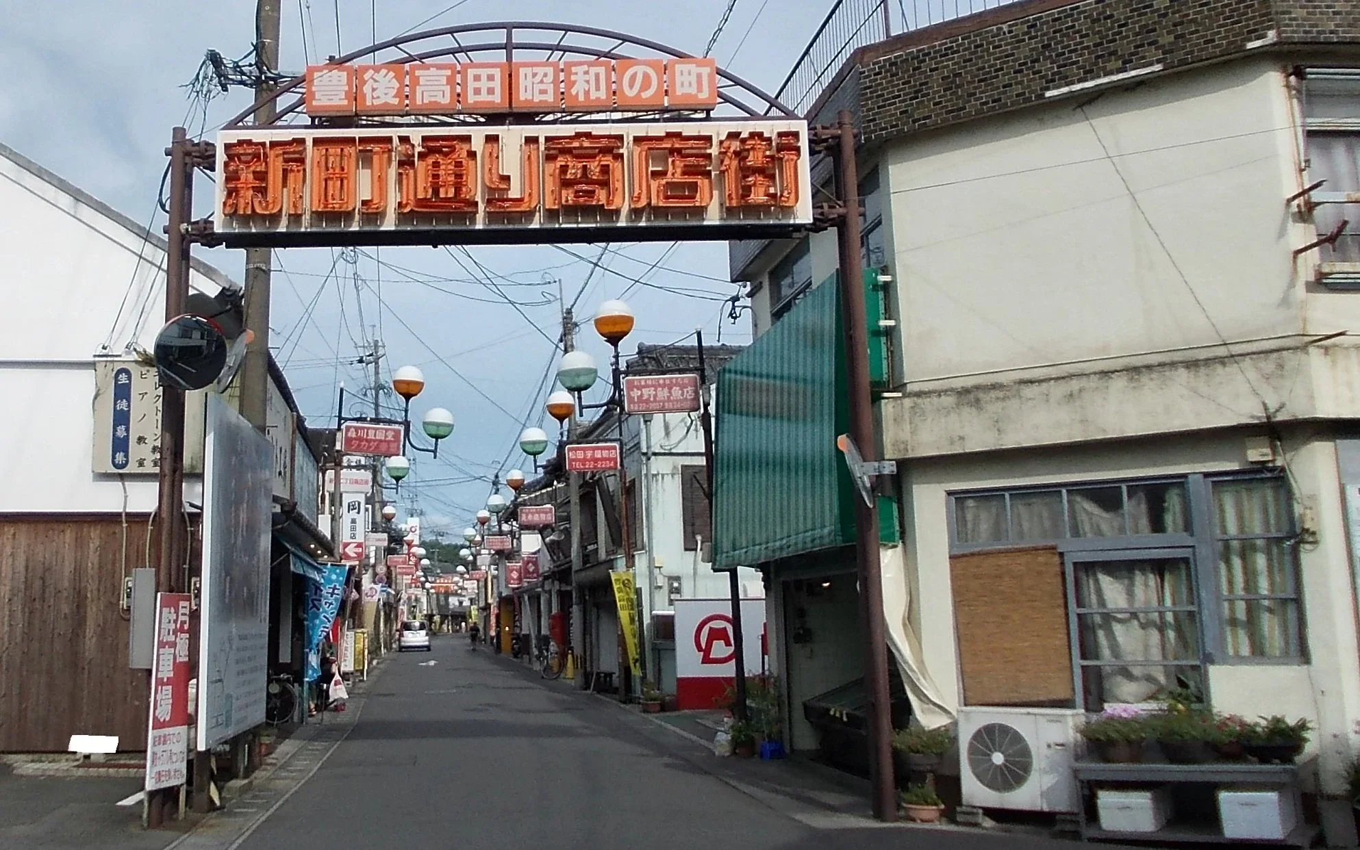 豐後高田昭和之町商店街入口招牌下延伸的街道與沿街店舖