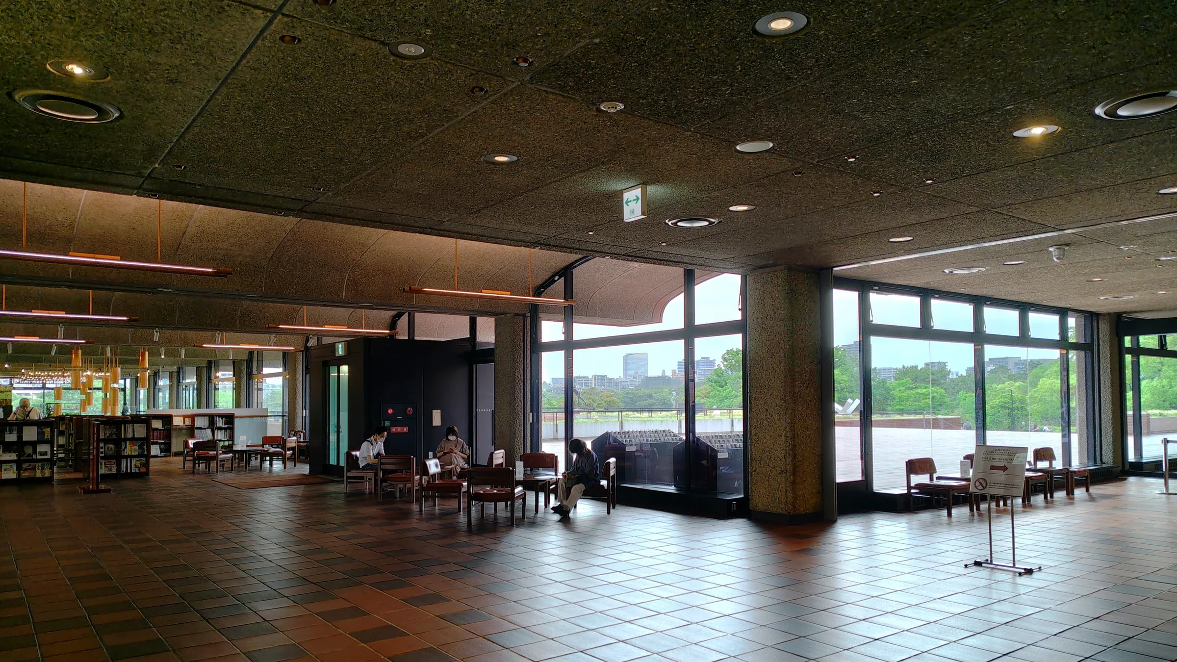 福岡市美術館二樓大廳的落地窗、座椅與窗外綠意