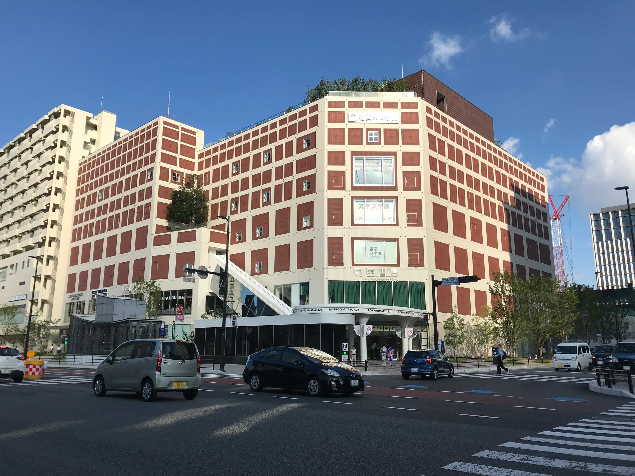 六本松421大樓外的福岡市科學館，白色與磚紅色立面朝向街口