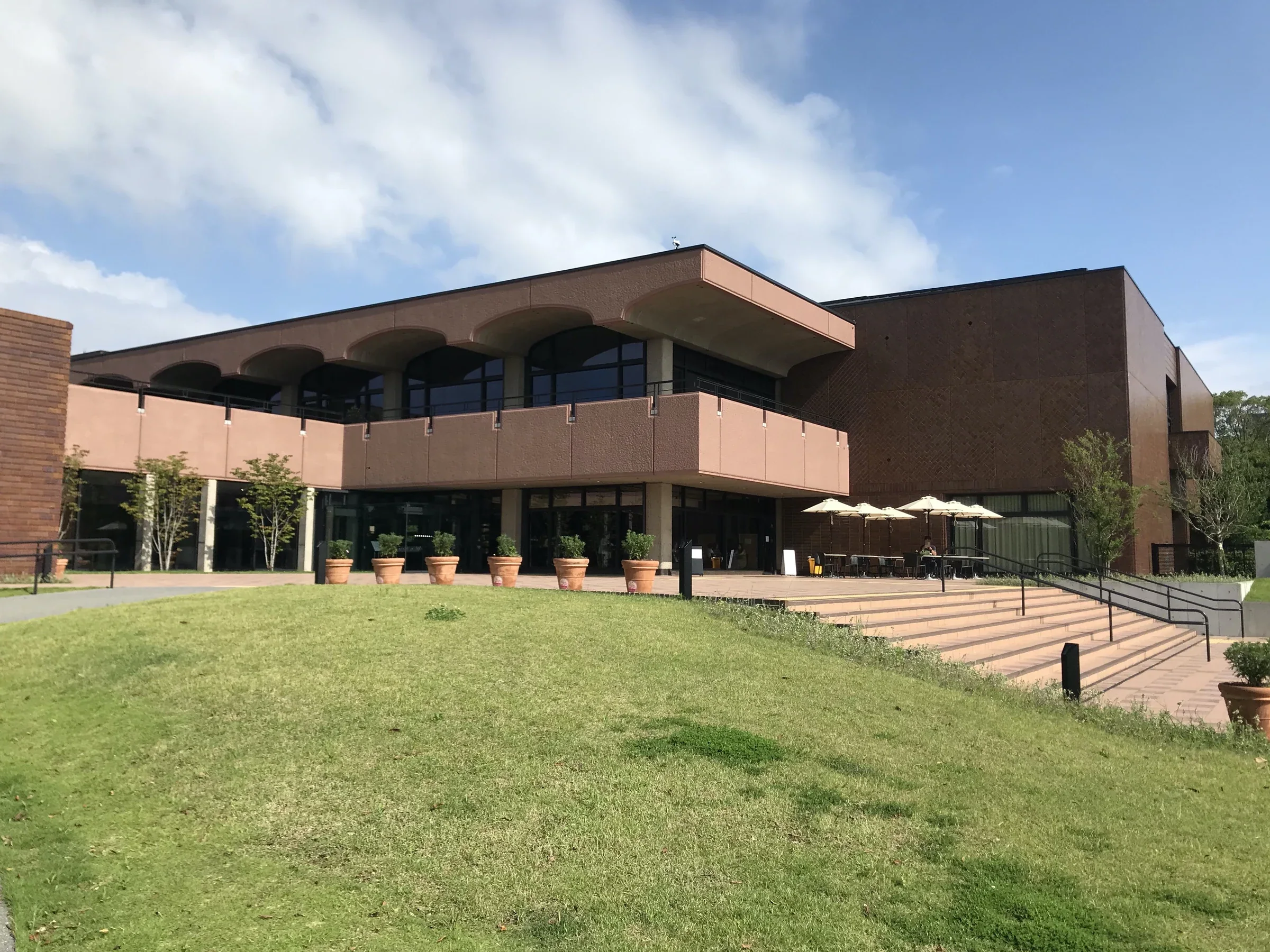福岡市美術館入口與前方草坡，右側可見通往入口的階梯和斜道