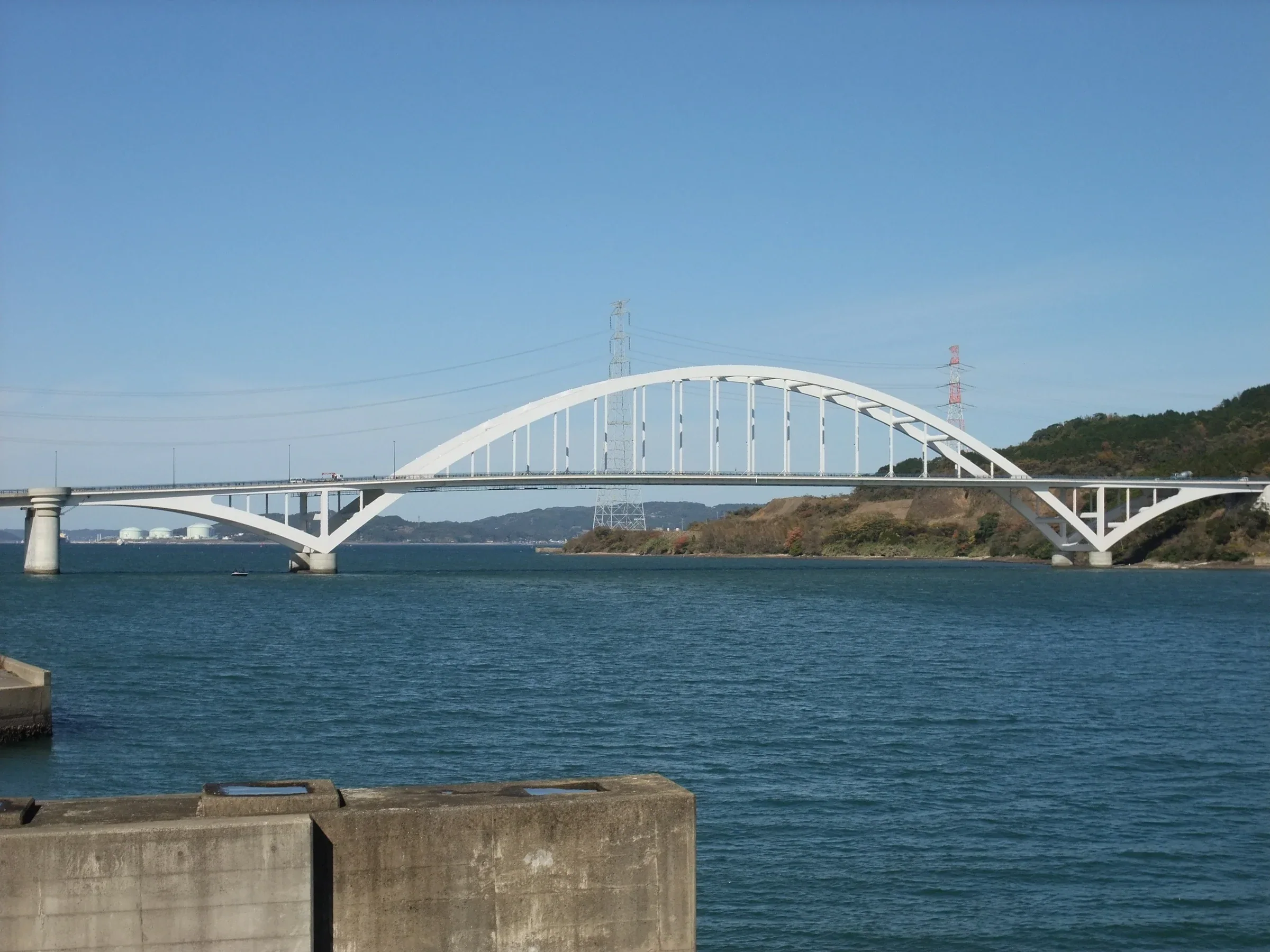 白色伊万里灣大橋橫跨海灣，遠處可見沿岸山坡