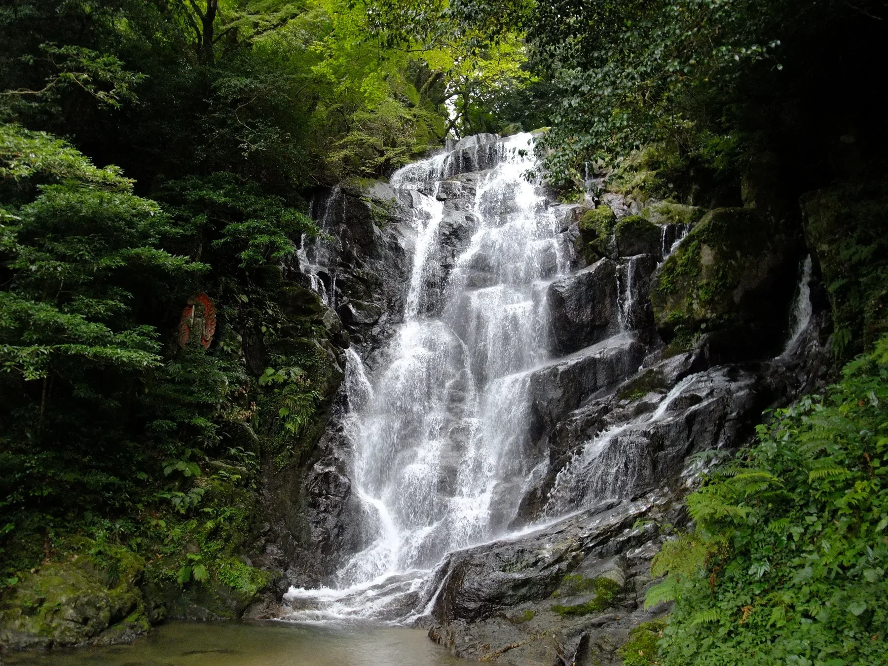 糸島白糸瀑布沿岩壁流下，四周被山林包圍