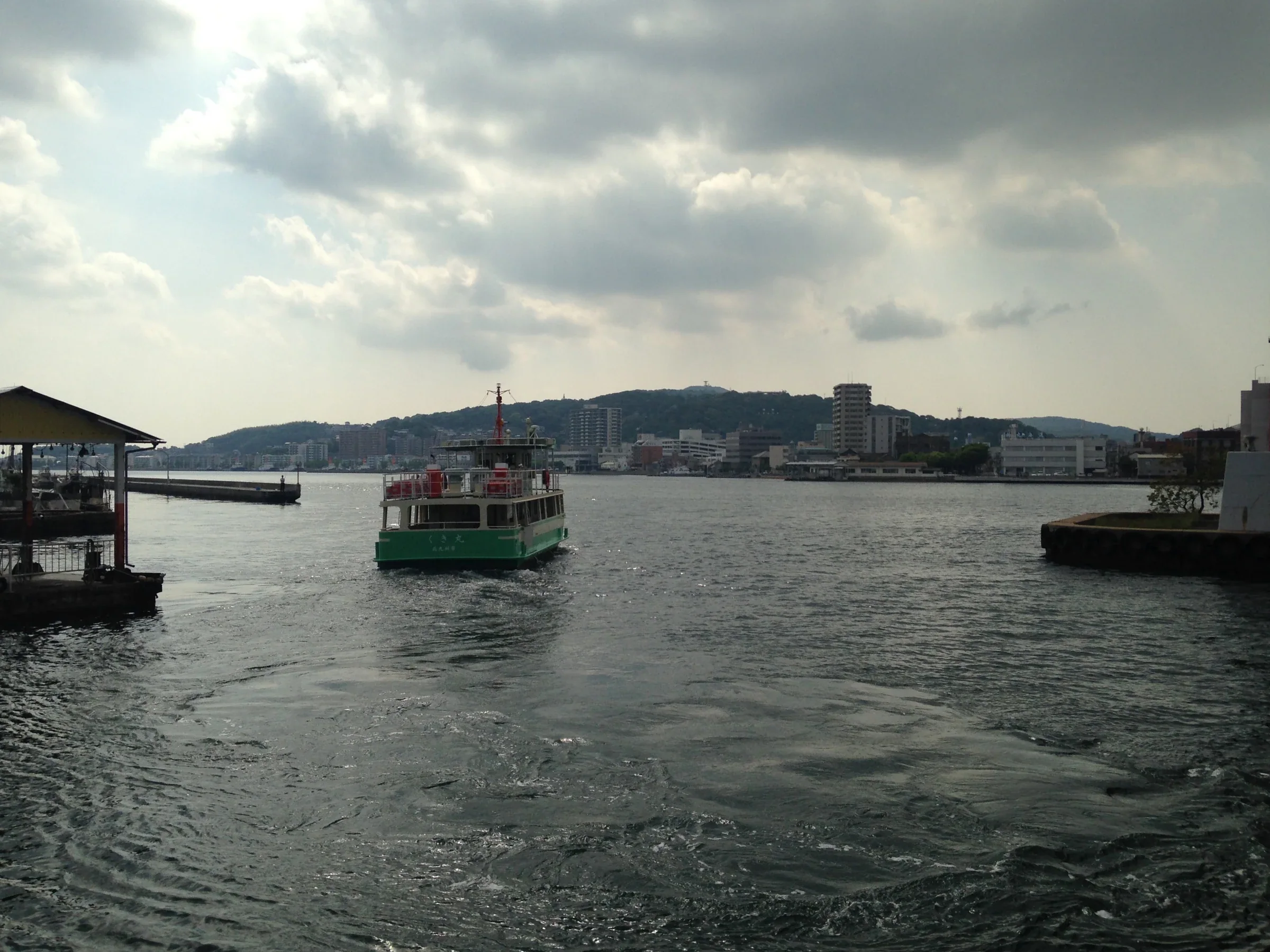 若戶渡船小型客船航行於洞海灣，岸邊是北九州港區景色