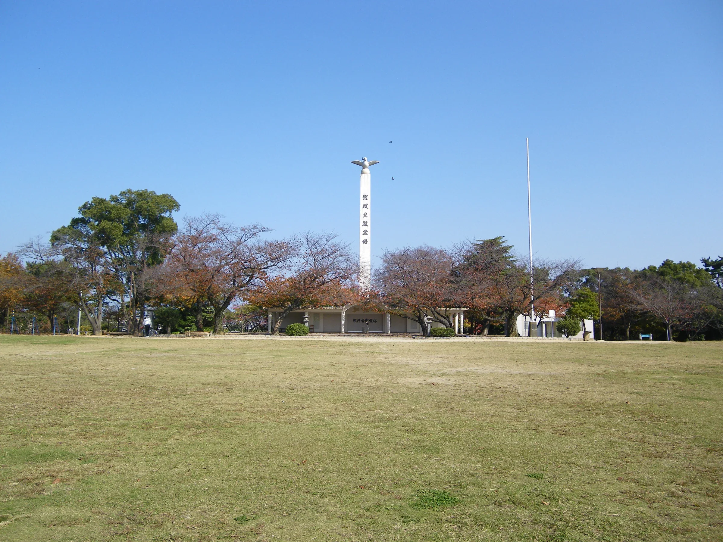 夜宮公園的草地、紀念碑和樹木，園區有寬闊開放空間