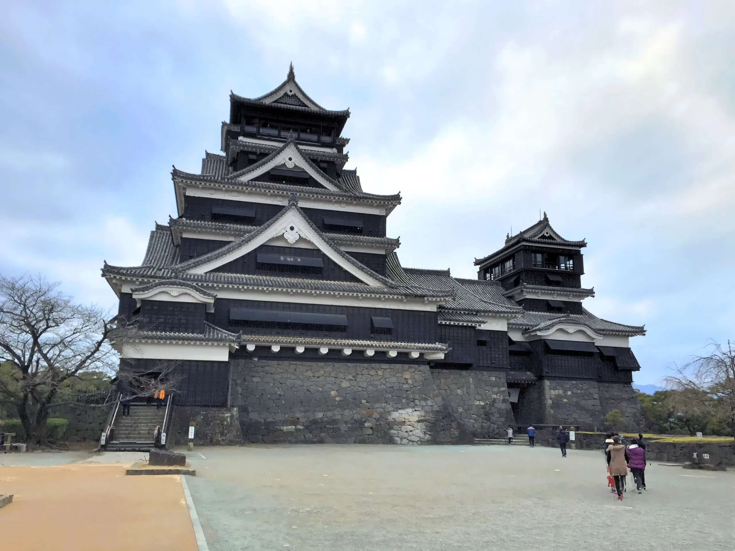 熊本城天守與本丸建築群，城牆前可見少量遊客