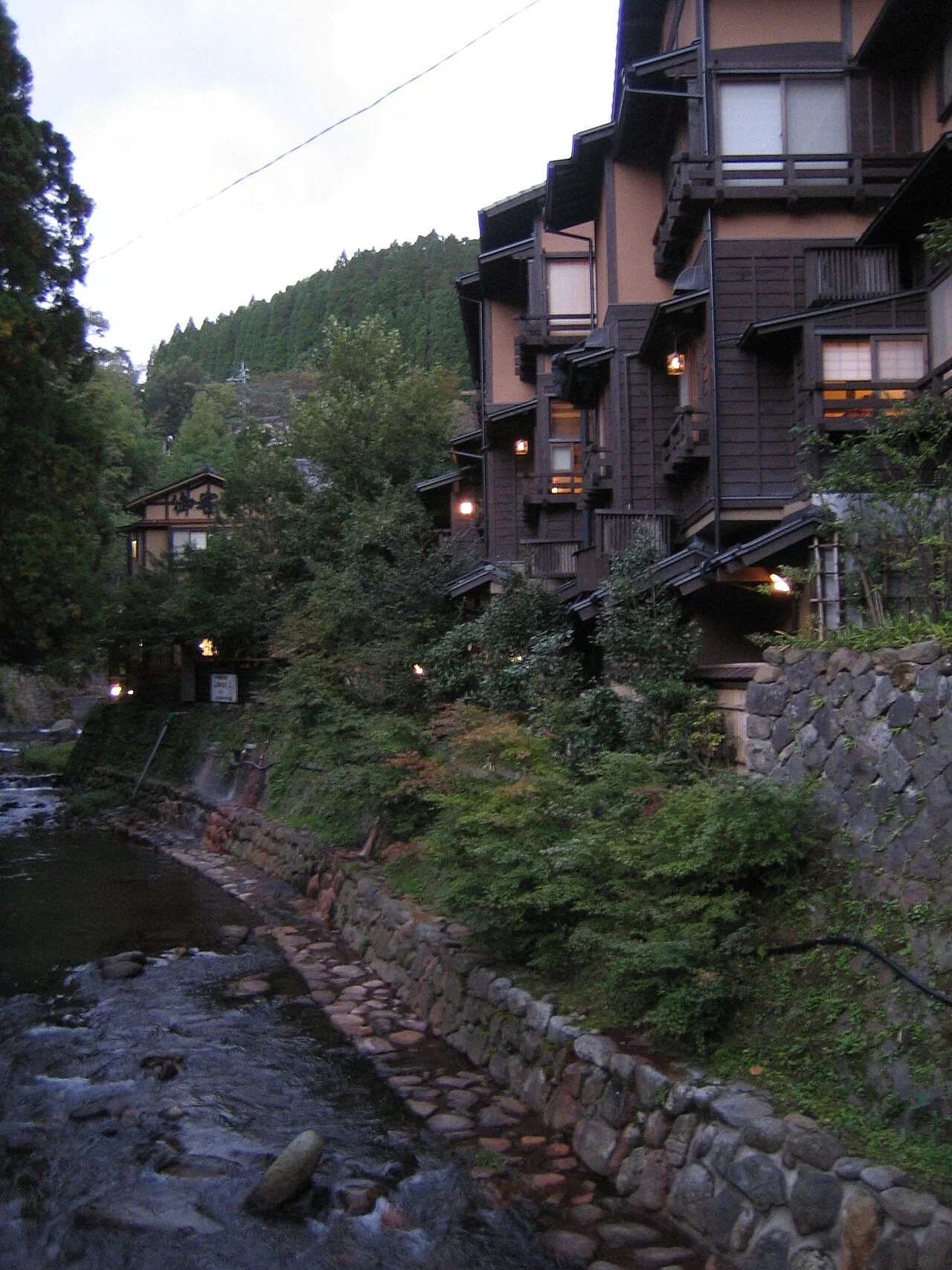 黑川溫泉沿溪旅館、石岸步道與山坡建築