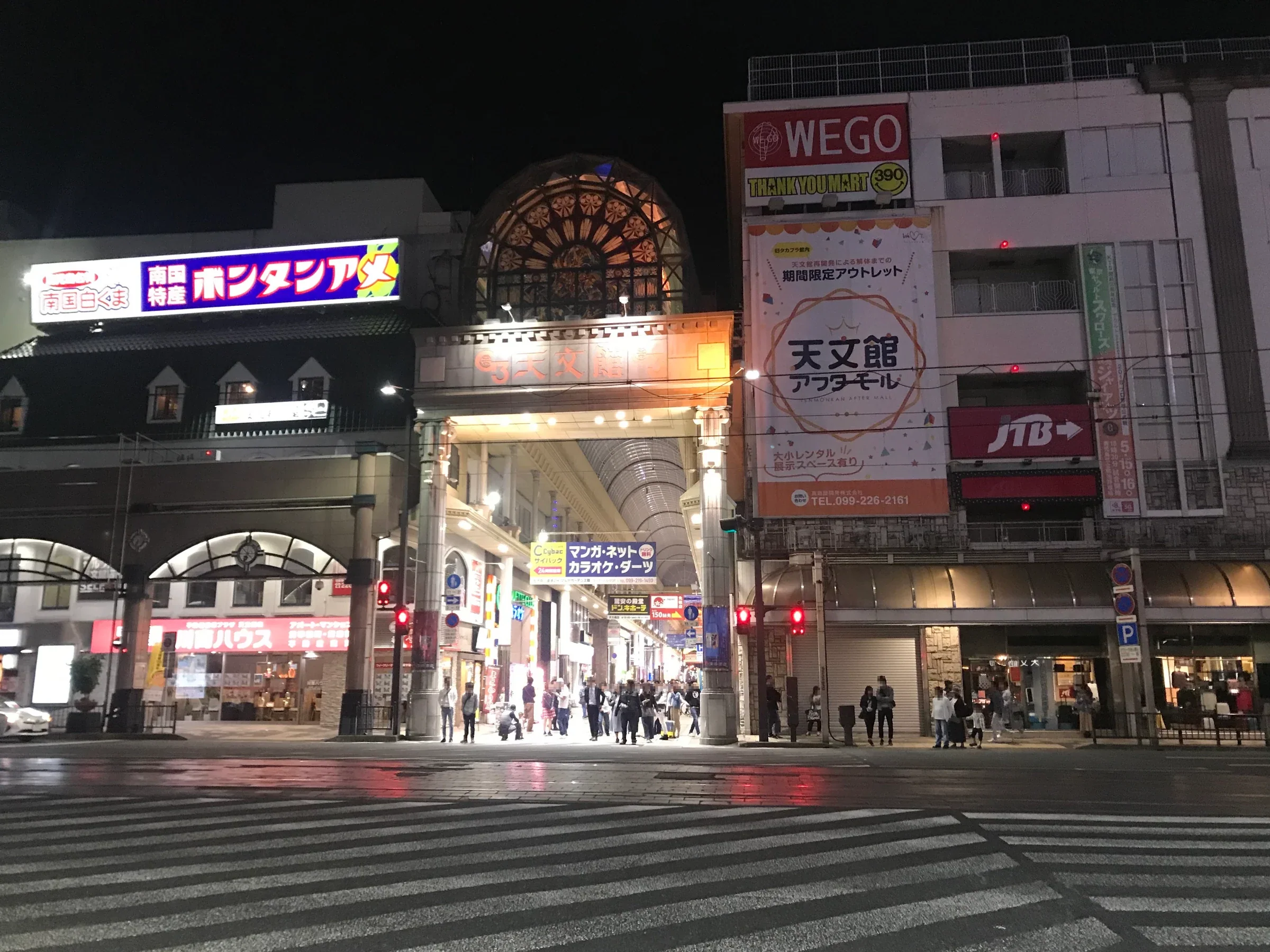 夜間亮燈的天文館拱廊商店街，店舖沿有遮雨屋頂的步行道排列