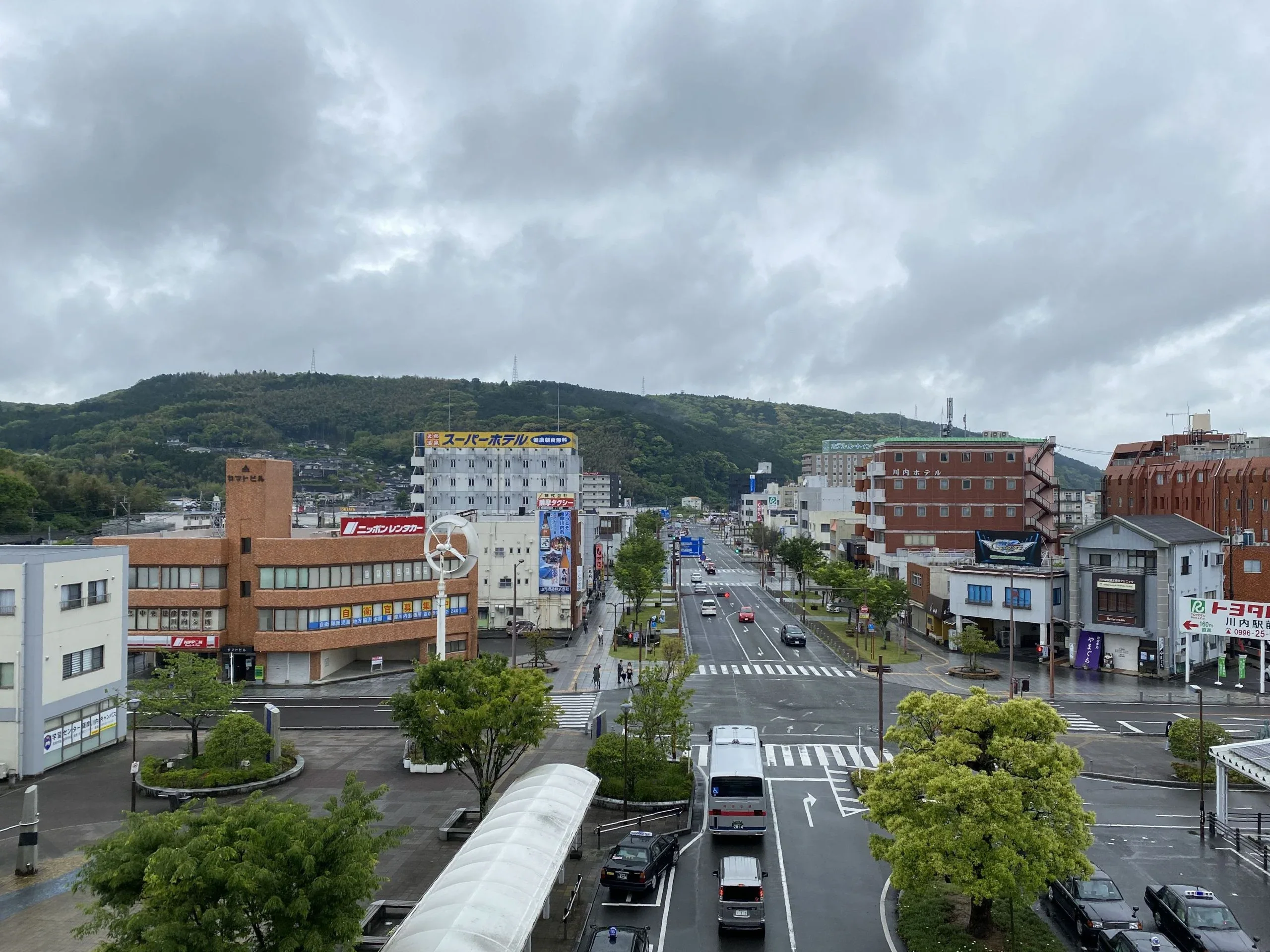 薩摩川內市區街道、車站前建築與周邊山景