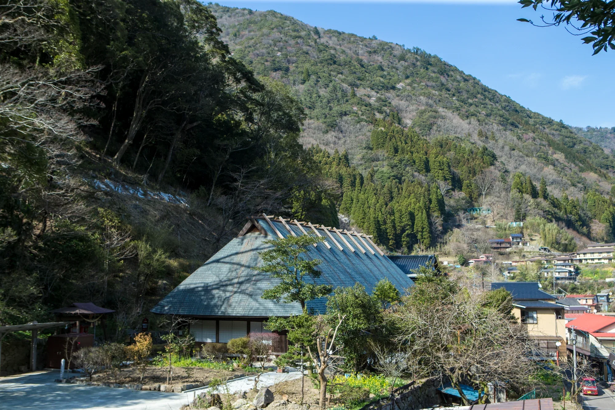 椎葉村鶴富屋敷外觀，屋前空地與山坡聚落呈現上椎葉的地形