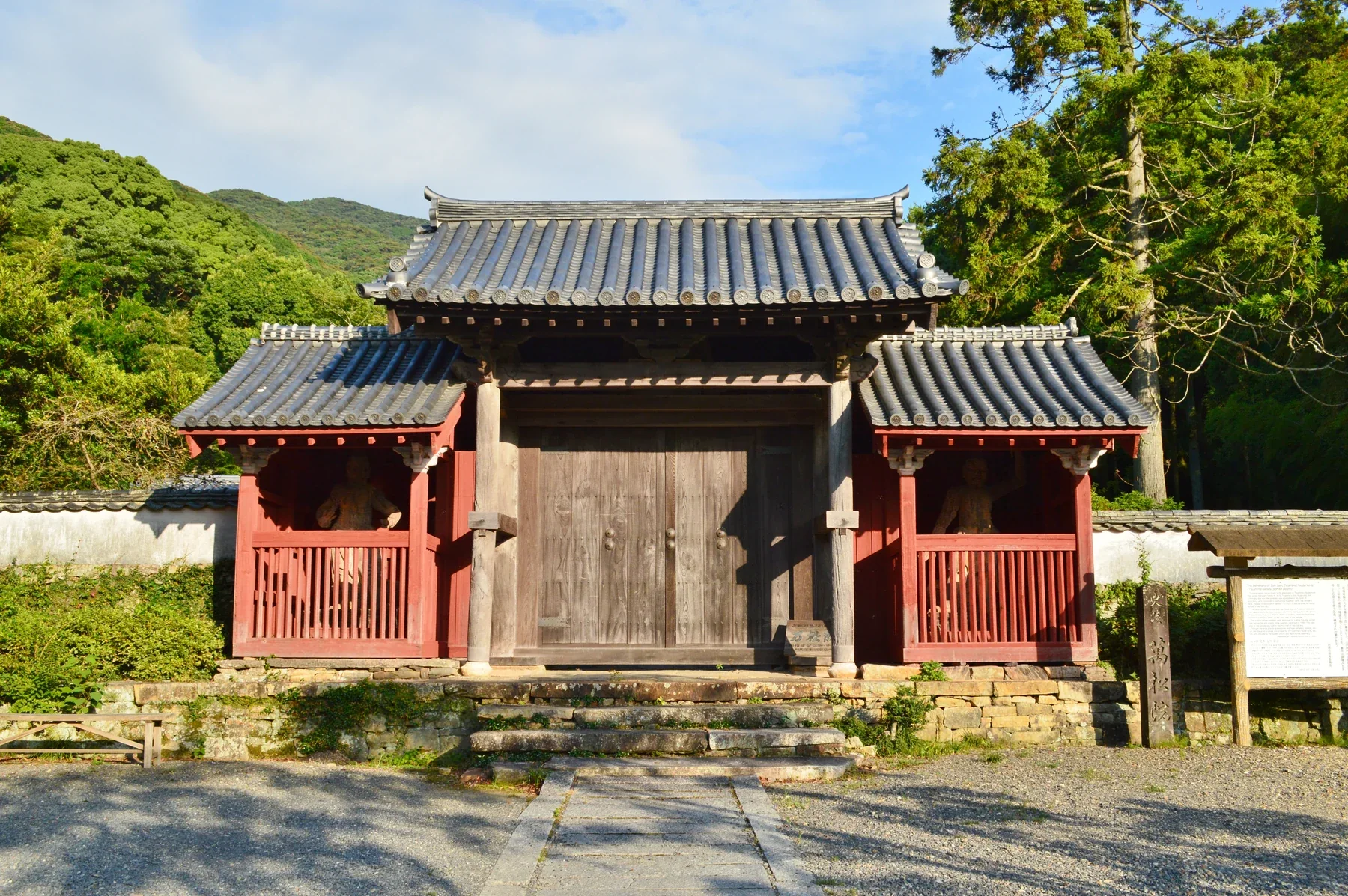 對馬萬松院木造山門與門前短石階，兩側有樹林