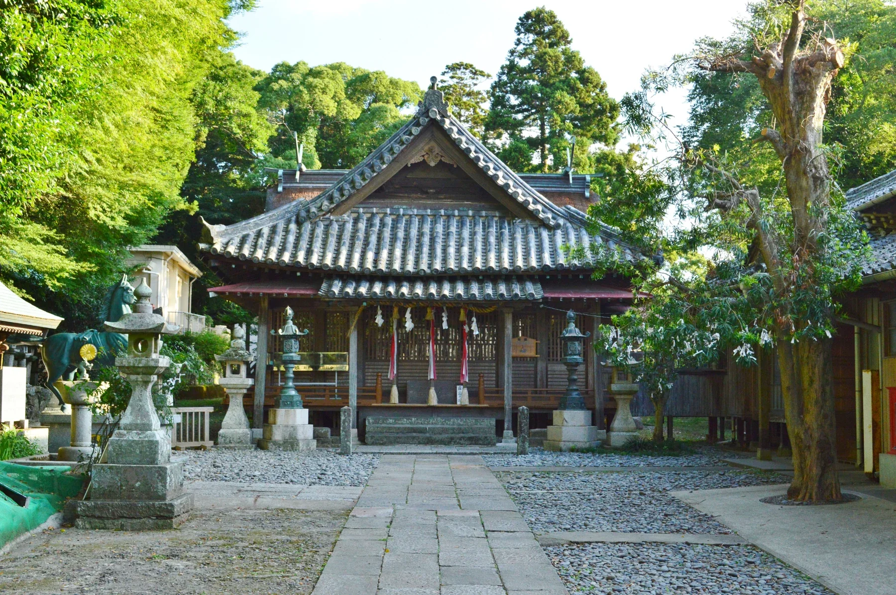 嚴原八幡宮拜殿立於樹影之下，前方可見石燈籠與參道