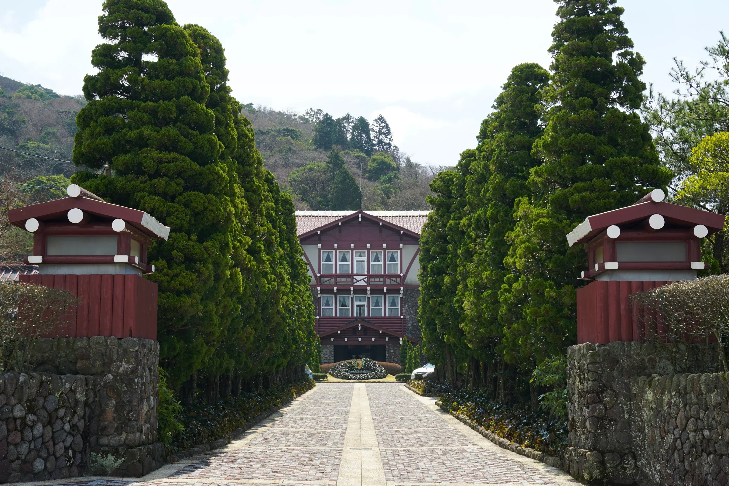 雲仙觀光酒店入口前的石牆、松樹步道與山間木構建築