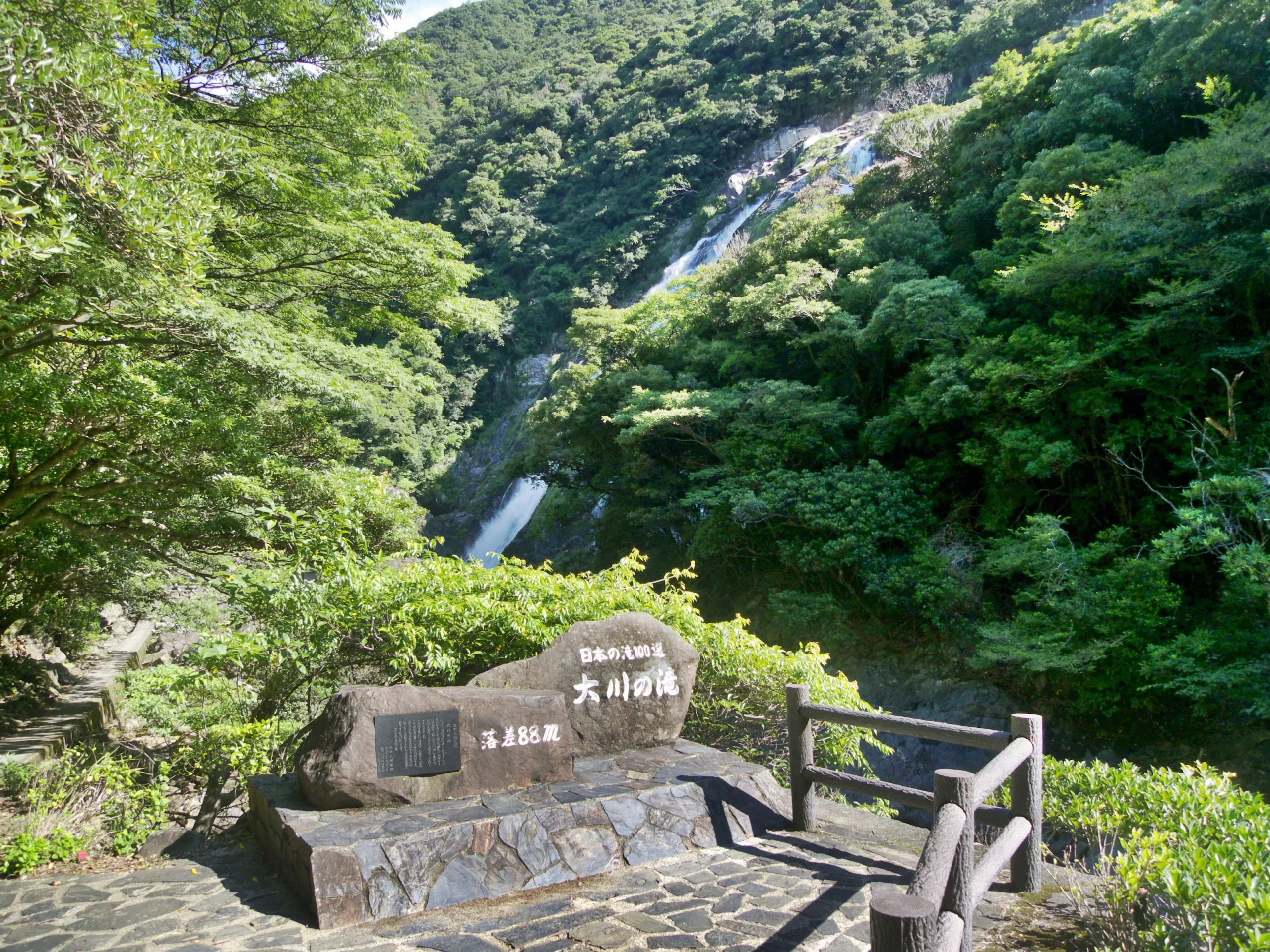 從屋久島大川瀑布前方步道遠望完整瀑布與落差標示